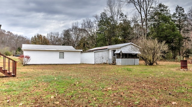 back of house with a lawn and an outbuilding