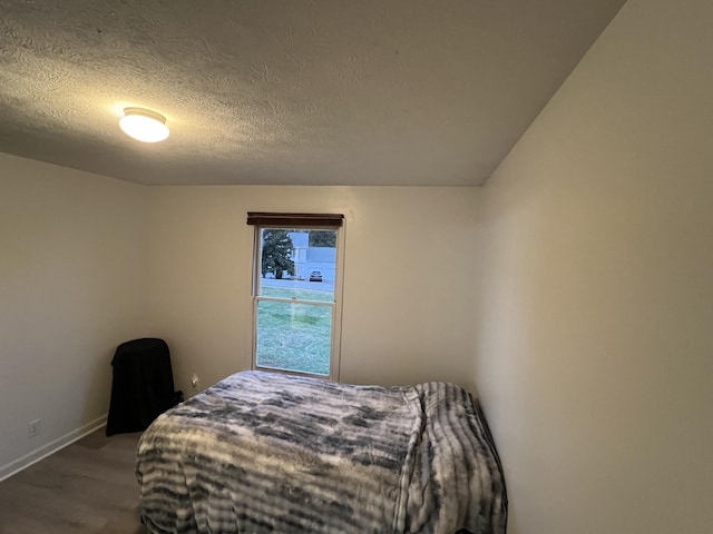 bedroom featuring a textured ceiling and wood-type flooring