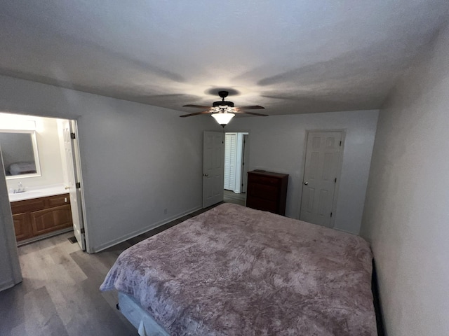 bedroom with ceiling fan, sink, and ensuite bath