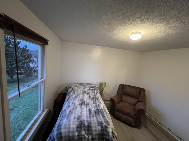 bedroom with a textured ceiling and hardwood / wood-style flooring