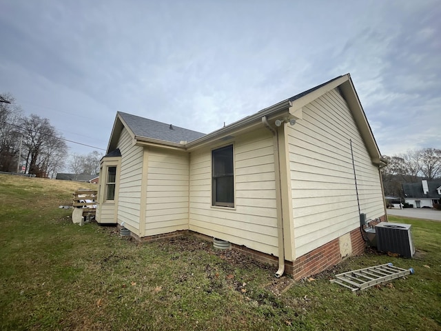 view of home's exterior with central AC unit and a lawn