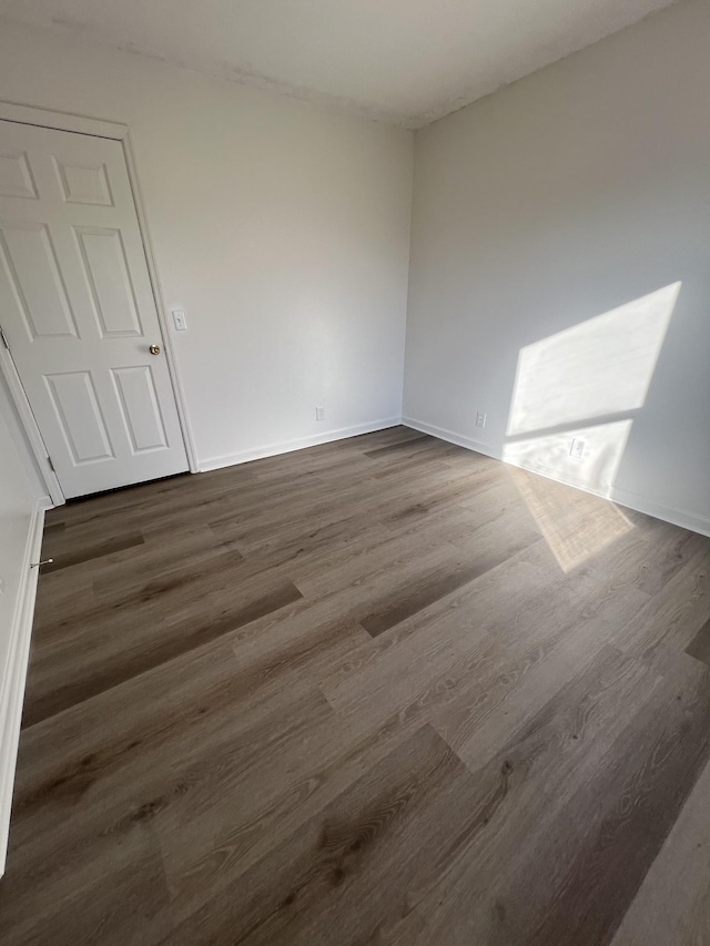 unfurnished room with dark hardwood / wood-style flooring