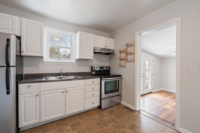 kitchen with stainless steel appliances, ceiling fan, sink, hardwood / wood-style floors, and white cabinetry