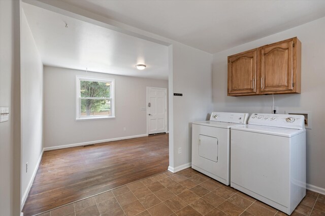 laundry room featuring cabinets, hardwood / wood-style floors, and washing machine and dryer