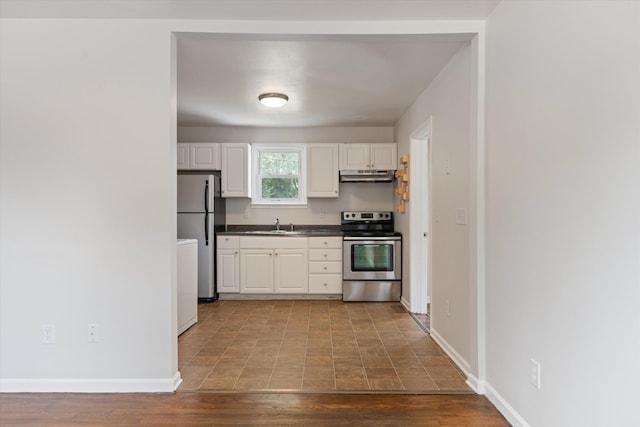 kitchen with white cabinets, appliances with stainless steel finishes, light hardwood / wood-style flooring, and sink