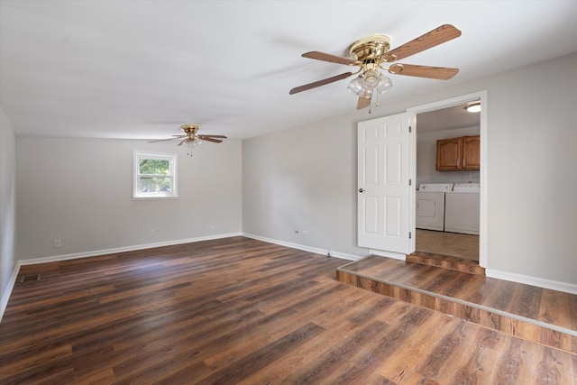 empty room featuring dark hardwood / wood-style floors, ceiling fan, and washing machine and clothes dryer