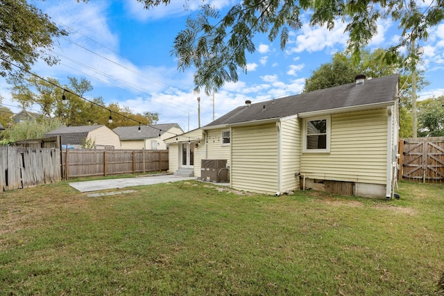 rear view of property featuring a lawn and a patio