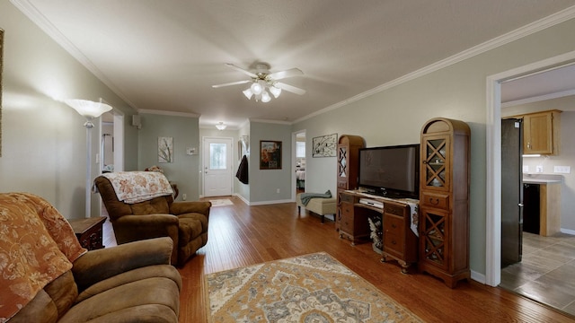 living room featuring crown molding, light hardwood / wood-style flooring, and ceiling fan