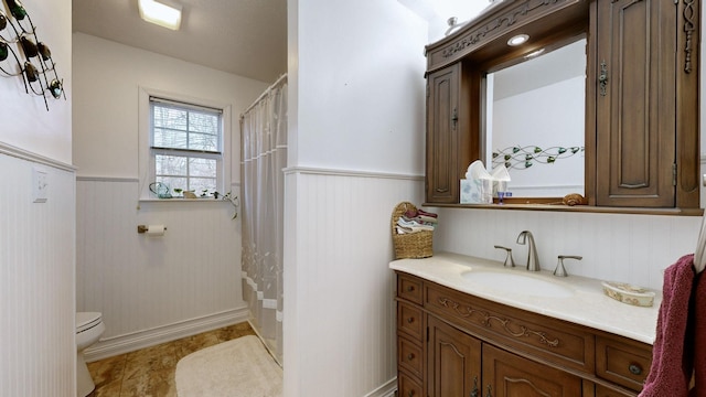 bathroom featuring a shower with shower curtain, vanity, and toilet