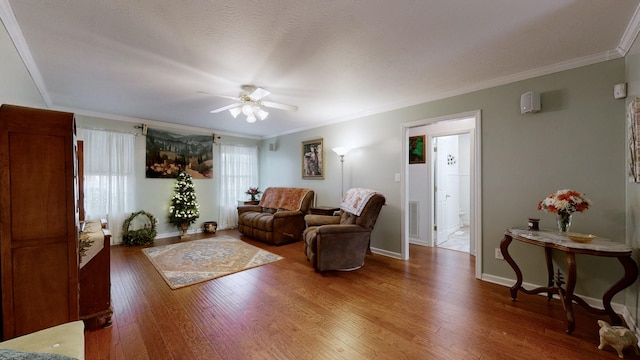 living room with ceiling fan, wood-type flooring, and ornamental molding