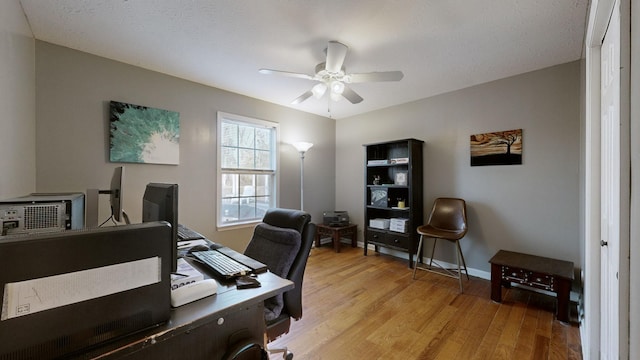 office area featuring ceiling fan, light hardwood / wood-style floors, and a textured ceiling