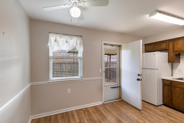 kitchen featuring light wood-type flooring, white refrigerator, plenty of natural light, and ceiling fan