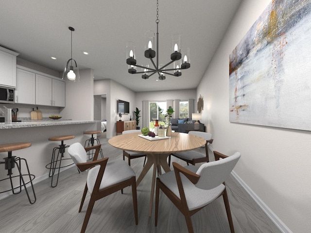 dining space featuring light hardwood / wood-style flooring and an inviting chandelier