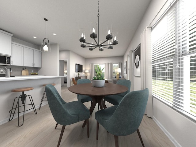 dining space with light hardwood / wood-style floors, plenty of natural light, a notable chandelier, and sink