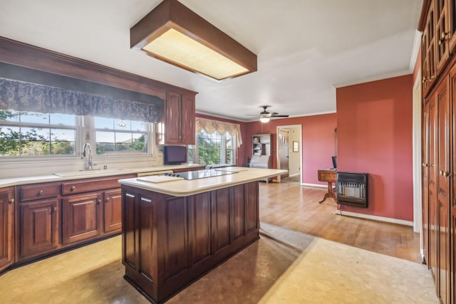 kitchen featuring a center island, crown molding, ceiling fan, light wood-type flooring, and heating unit