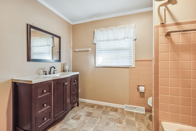 bathroom with crown molding, vanity, tile walls, and toilet