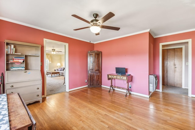 misc room with light hardwood / wood-style floors, ceiling fan, and crown molding