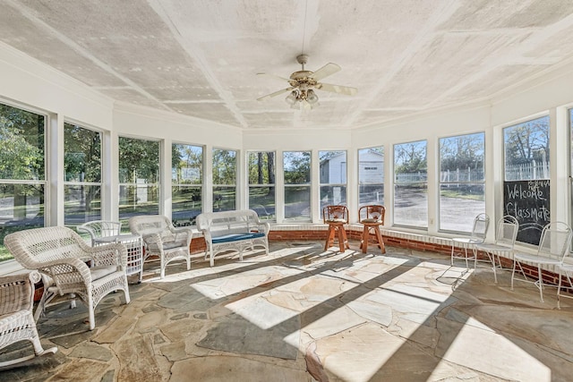 unfurnished sunroom with ceiling fan