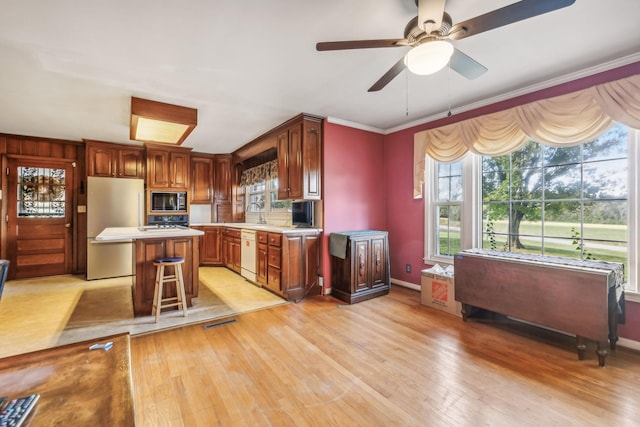 kitchen with dishwasher, a kitchen breakfast bar, a kitchen island, and a wealth of natural light