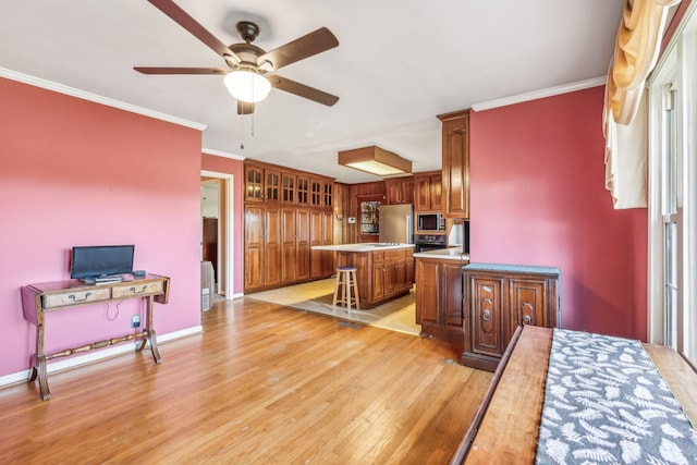 kitchen featuring a breakfast bar, a kitchen island, light hardwood / wood-style floors, and ornamental molding