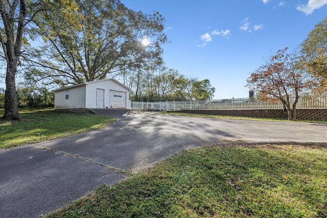 view of yard featuring a garage and an outbuilding