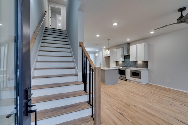 stairs featuring wood-type flooring and sink