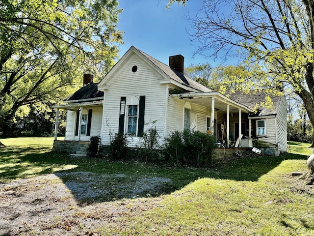 view of front of home with covered porch and a front lawn