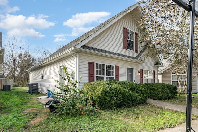 view of property exterior with central AC and a yard