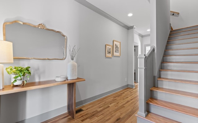 staircase featuring hardwood / wood-style flooring and ornamental molding