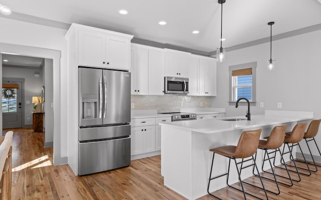 kitchen with appliances with stainless steel finishes, white cabinetry, plenty of natural light, and sink