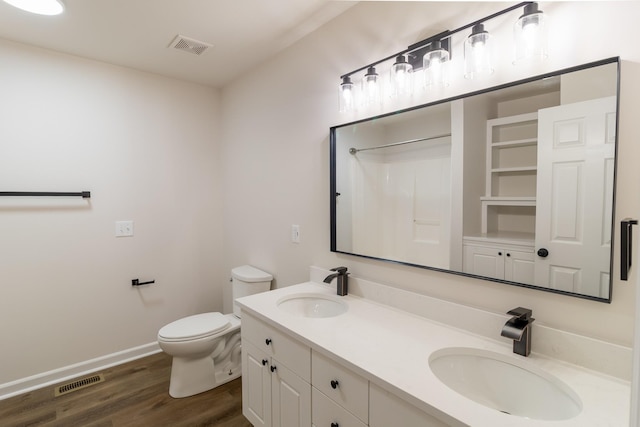 bathroom featuring vanity, toilet, wood-type flooring, and a shower