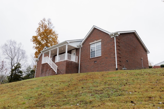 view of side of property with a porch and a yard