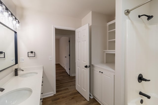 bathroom featuring hardwood / wood-style flooring, vanity, and washtub / shower combination