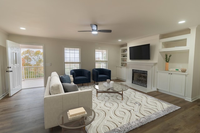 living room featuring ceiling fan, dark hardwood / wood-style flooring, and built in features