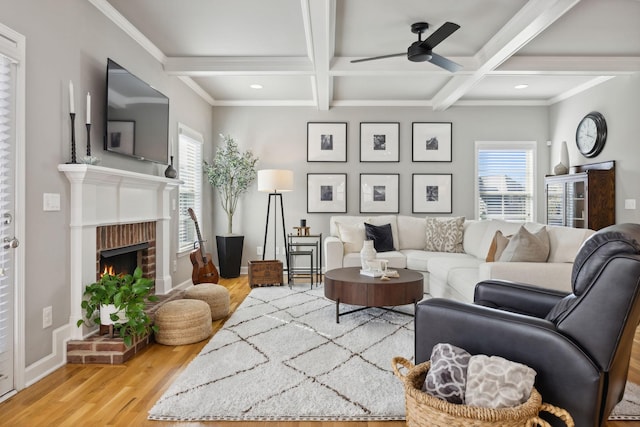 living room with a fireplace, hardwood / wood-style floors, plenty of natural light, and beamed ceiling