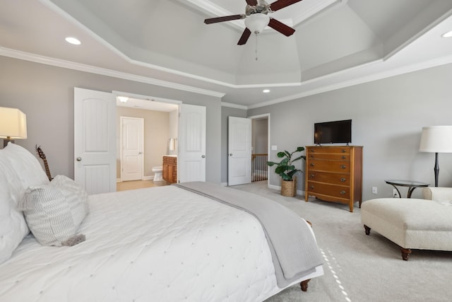 bedroom featuring ensuite bathroom, a raised ceiling, crown molding, ceiling fan, and light colored carpet