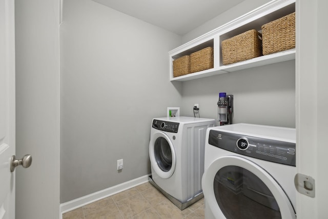 clothes washing area featuring washer and clothes dryer and light tile patterned floors