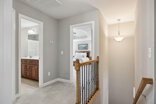 hall featuring light colored carpet and sink