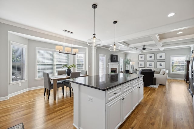 kitchen featuring pendant lighting, coffered ceiling, white cabinets, light wood-type flooring, and a kitchen island