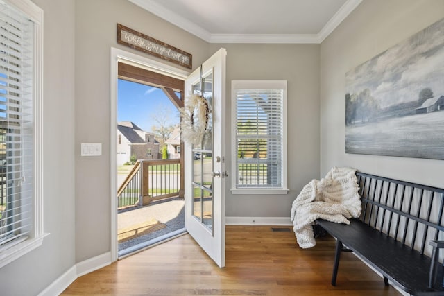 doorway to outside featuring wood-type flooring, plenty of natural light, and crown molding