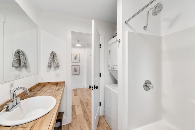 bathroom with hardwood / wood-style floors, vanity, and a shower