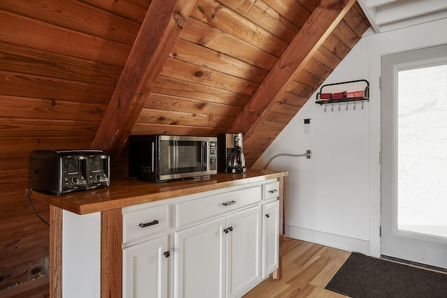 interior space with white cabinetry, wood counters, light hardwood / wood-style flooring, lofted ceiling, and wood ceiling