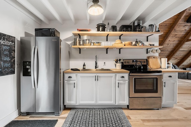 kitchen with white cabinets, beamed ceiling, and appliances with stainless steel finishes