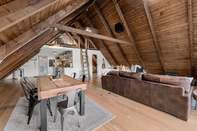 unfurnished dining area featuring vaulted ceiling with beams, light wood-type flooring, and wooden ceiling