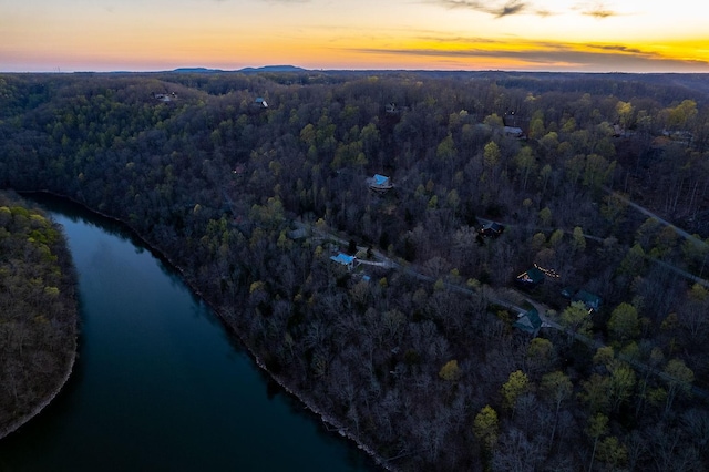 aerial view at dusk featuring a water view