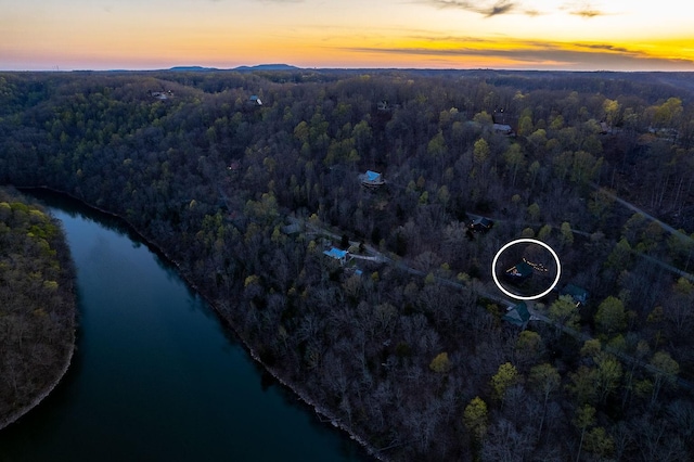 aerial view at dusk featuring a water view