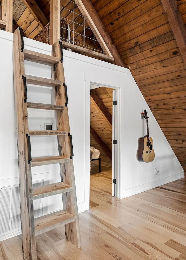 interior space featuring vaulted ceiling with beams, hardwood / wood-style floors, and wood ceiling