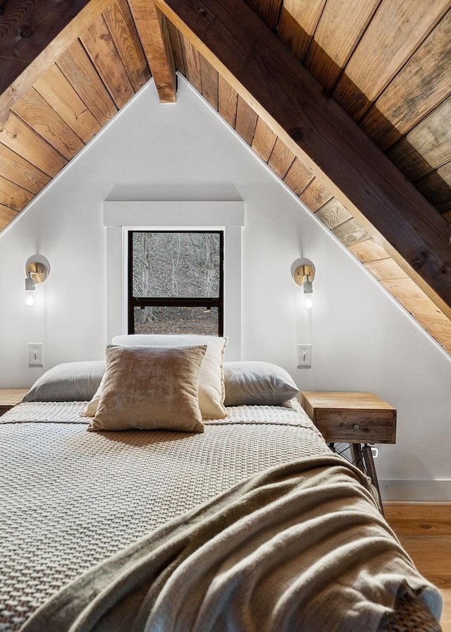 bedroom with vaulted ceiling with beams, wood-type flooring, and wood ceiling