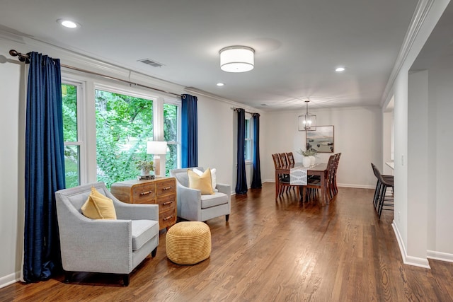 living area featuring crown molding and hardwood / wood-style flooring