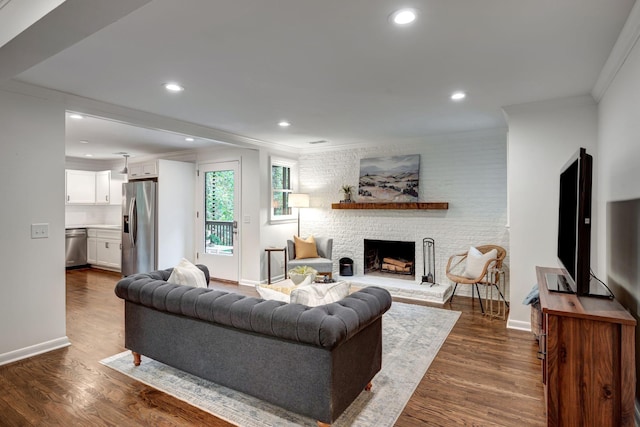 living room featuring a stone fireplace, crown molding, and dark hardwood / wood-style flooring